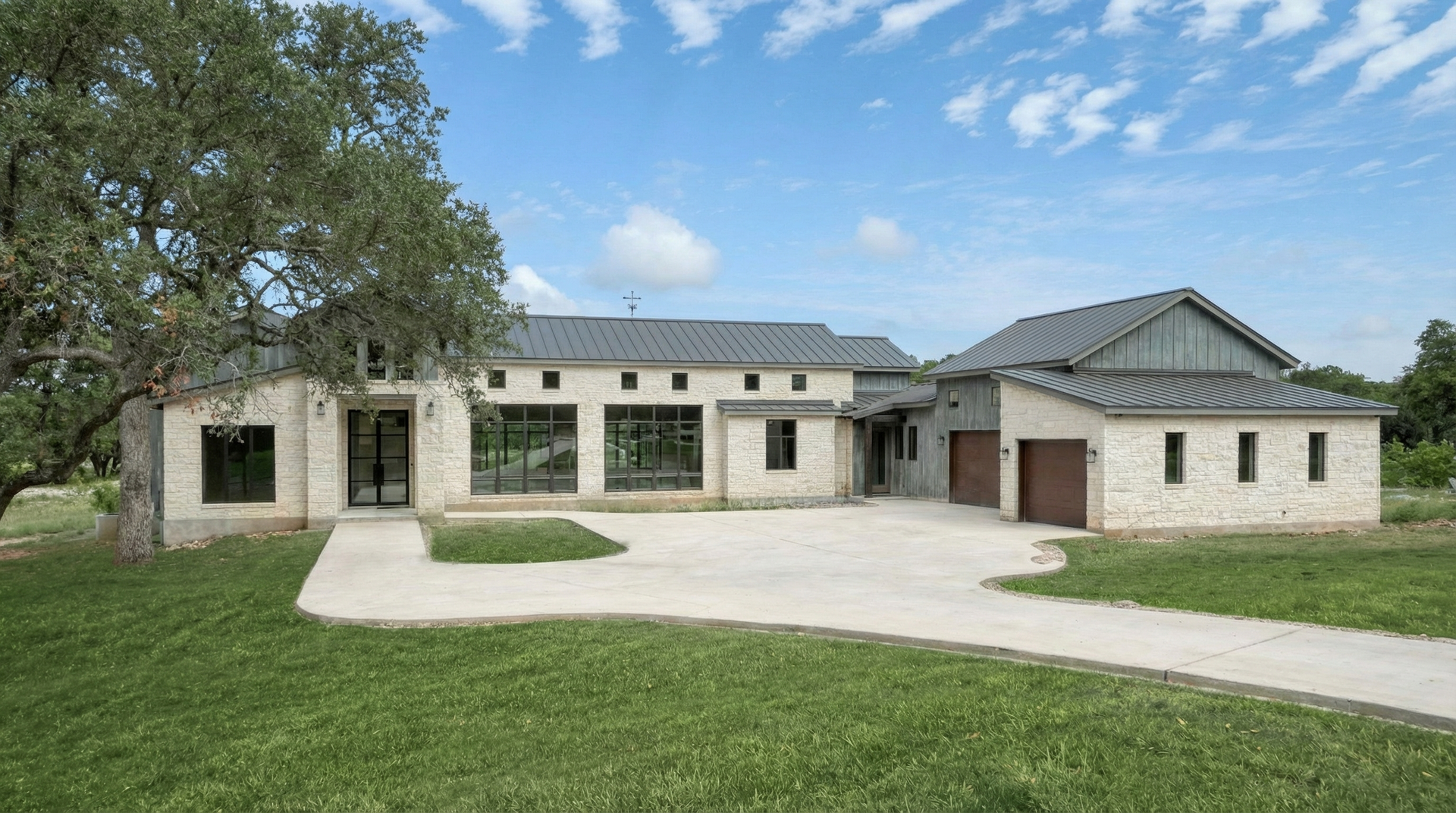 Texas Hill Country home + Metal roof and limestone facade designed by Hyden Design Group.